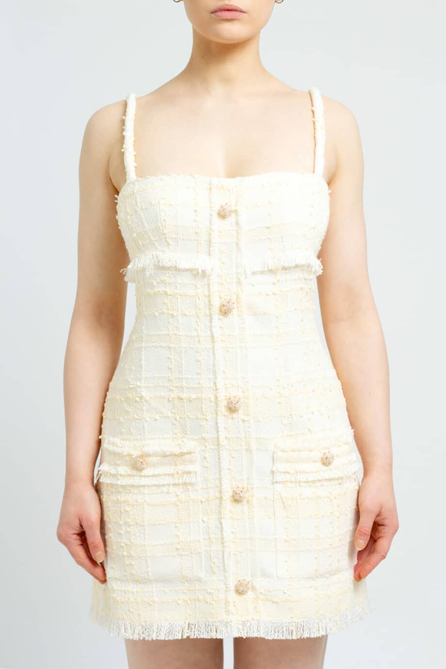 Short, sleeveless tweed dress with patched pockets